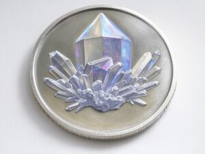 A silver coin with a crystal on it